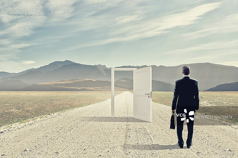 通往新机遇之门：商人站在敞开的门前做决定图片素材