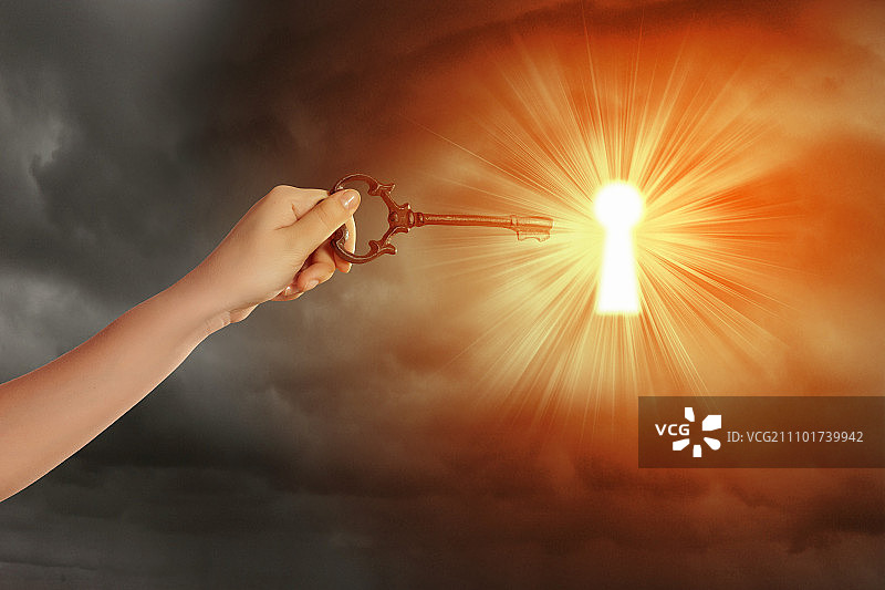手持钥匙插入锁孔图片素材