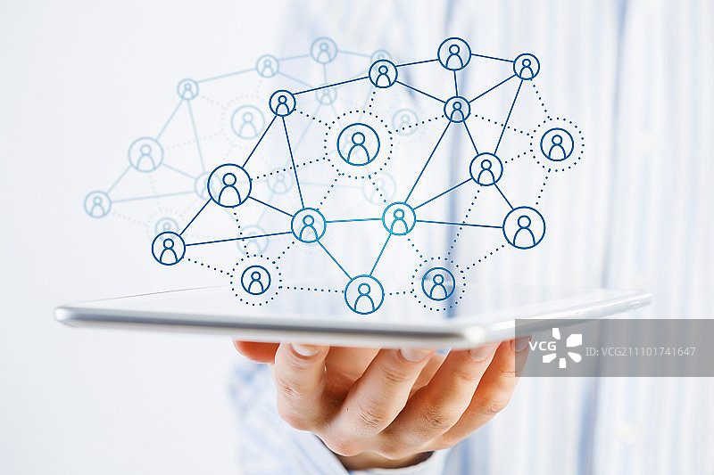 社交网络结构概念。商人手持平板电脑展示社交网络概念的近景图片素材