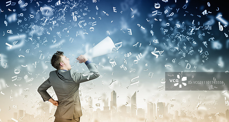 拿着小号的男人。年轻商人对着纸小号情绪激动地尖叫图片素材