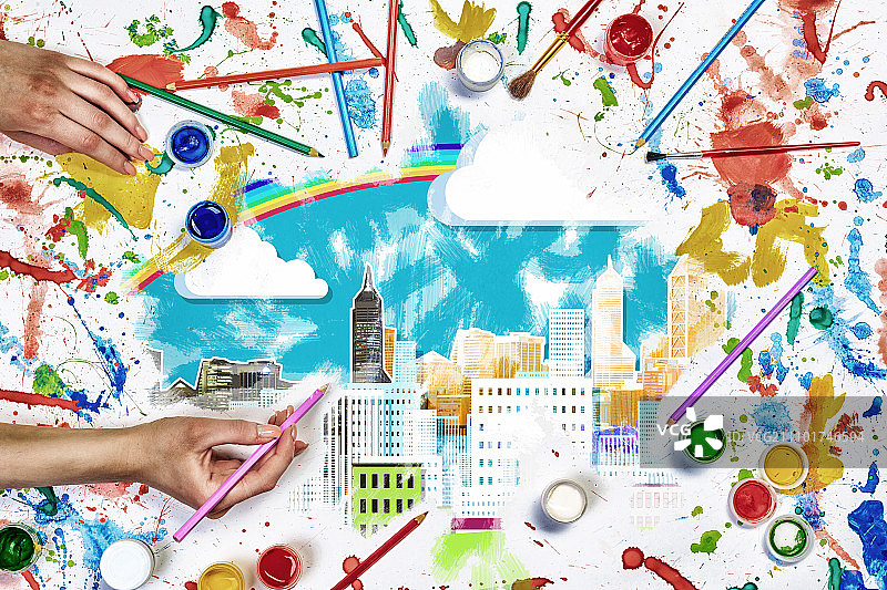创意城市设计：人们用颜料绘制城市概念的俯视图图片素材