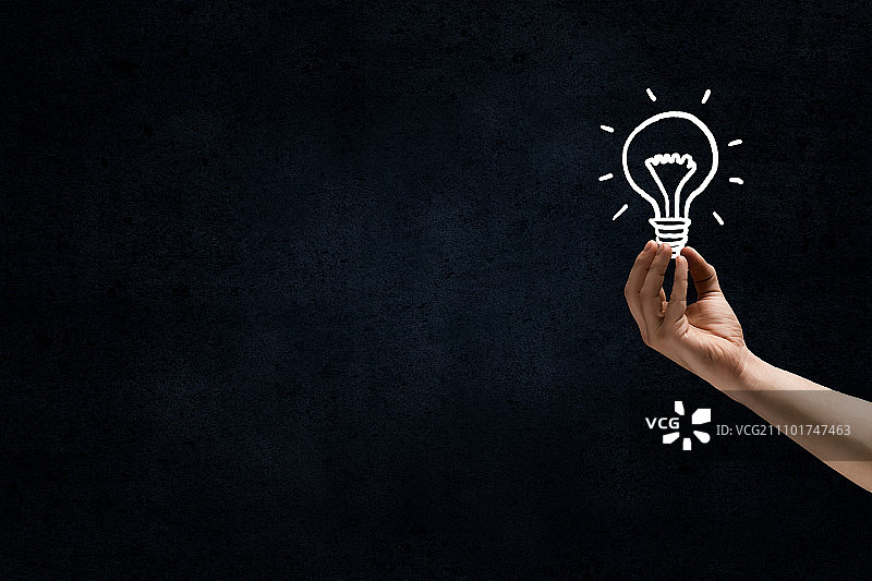 黑暗中的绝妙想法：深色背景上手绘灯泡图片素材