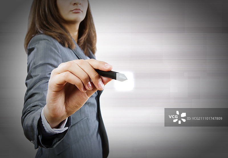 使用触屏笔在媒体屏幕上绘画的商务女性图片素材