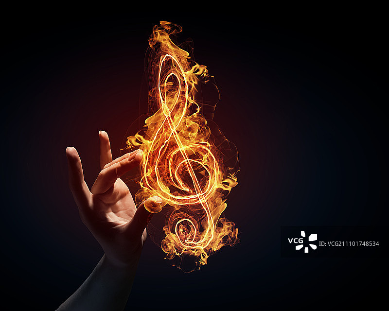 音乐概念图：黑暗背景上手中发光的音乐符号图片素材