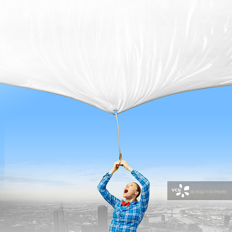 拿着banner的女人：拉着白色空白banner的休闲年轻女人图片素材