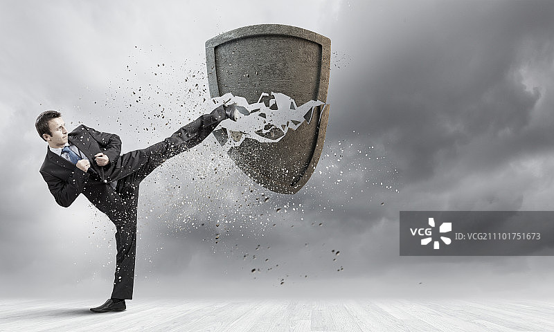 安全概念：商人以空手道击碎石盾图片素材