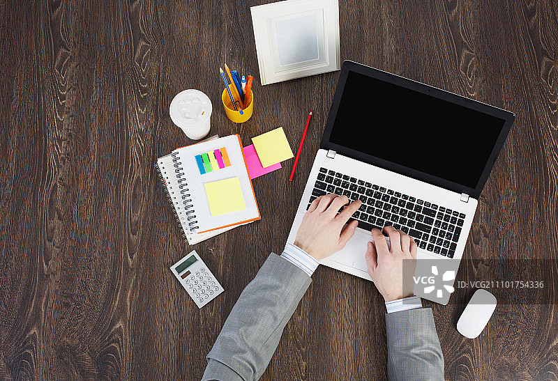 办公场所：桌面上的笔记本电脑和办公用品图片素材