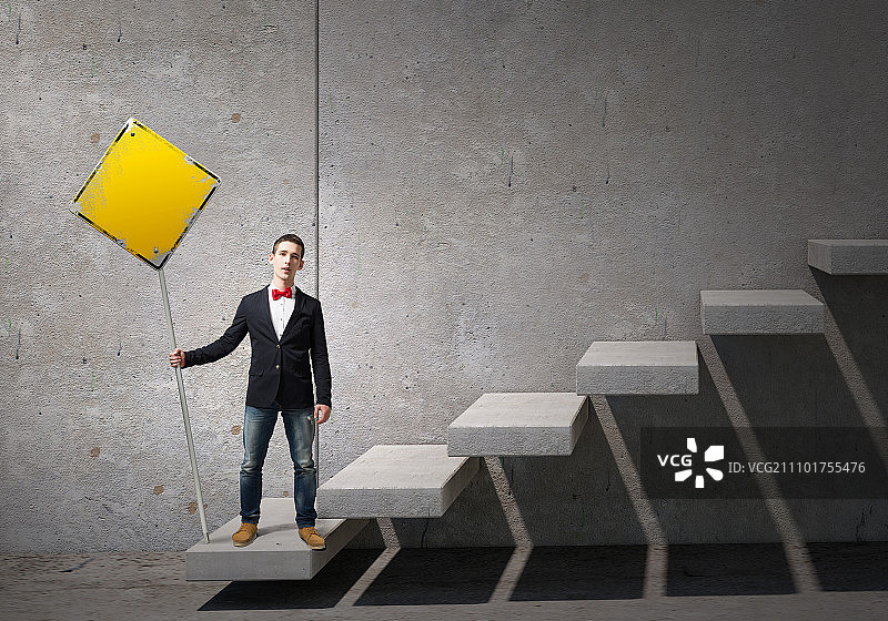 男子展示进步理念，身穿夹克和领结的年轻人举着标牌图片素材
