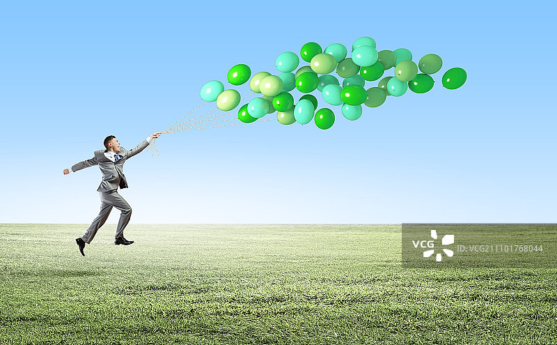 手拿气球的商人：快乐的商人拿着一束彩色气球奔跑图片素材
