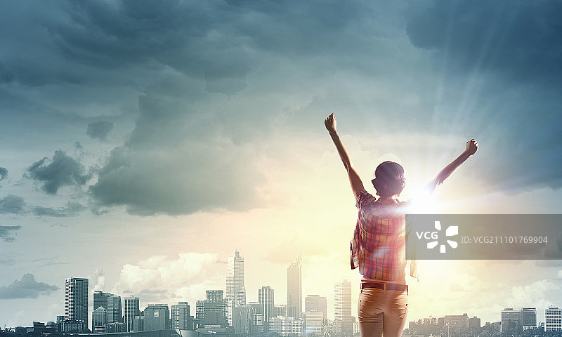 面朝新的一天：快乐的女子双手举起，面朝日出图片素材