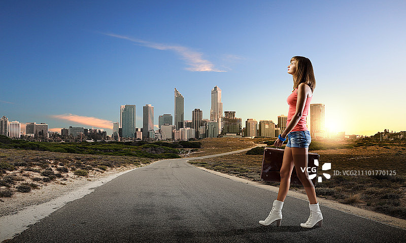 夏日假期，年轻漂亮的女子手提行李箱行走图片素材