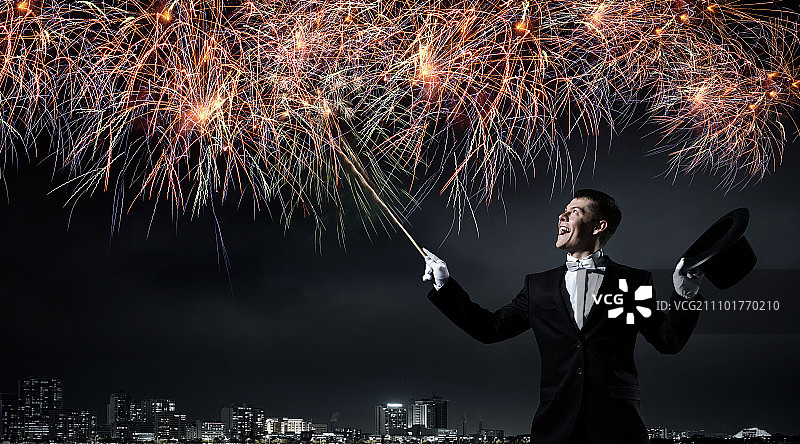 戴着高筒帽的男魔术师。年轻快乐的商人用魔法帽变戏法图片素材