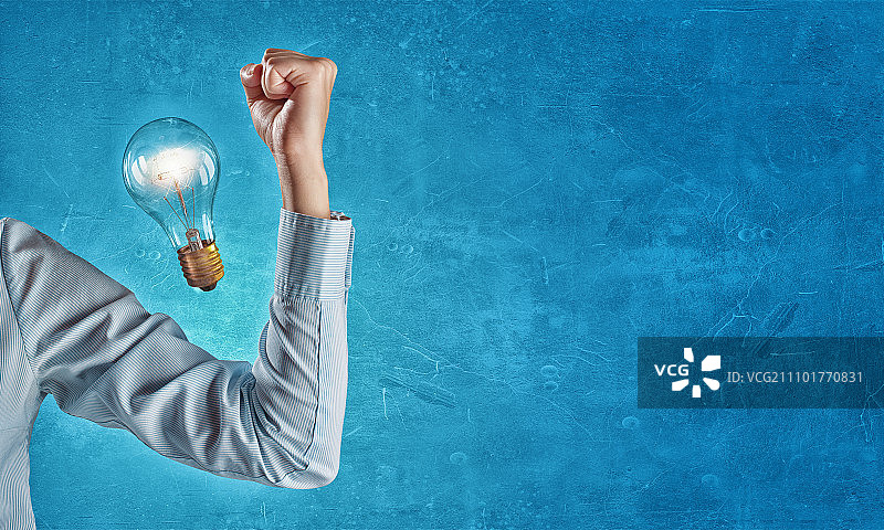 强大的商业理念：手持发光灯泡的商人图片素材
