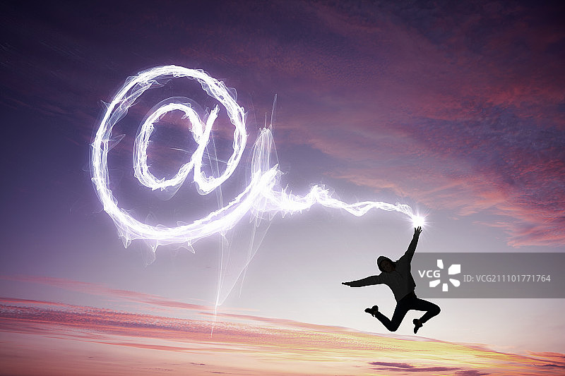 年轻快乐的女孩在空中跳跃并绘制符号图片素材