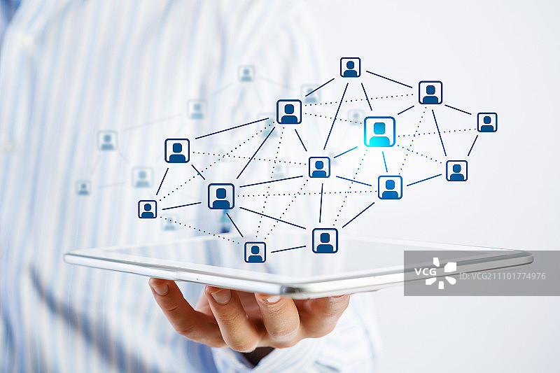 社交网络结构概念。商人手持平板电脑展示社交网络概念的近景图片素材