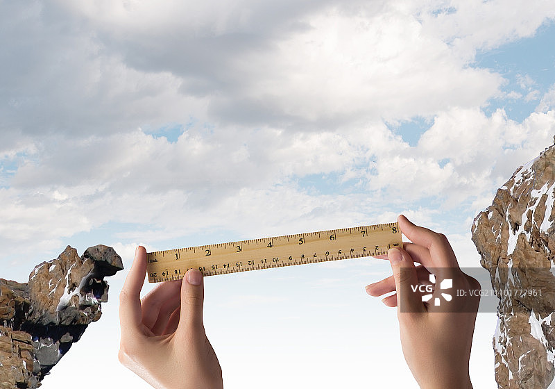 评估风险：用尺子测量间隙的人手特写图片素材