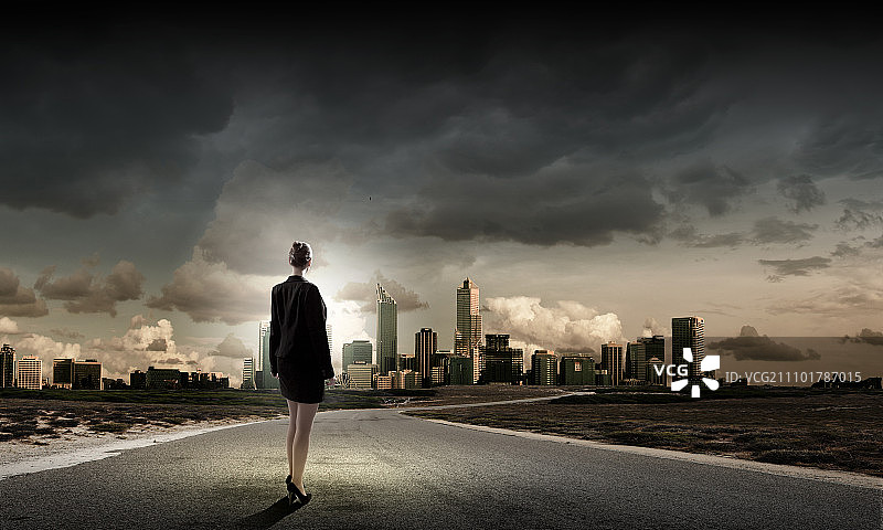 在路上的女商人。站在路上的女商人的后视图图片素材