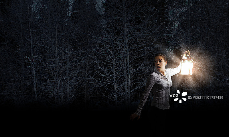 迷失的年轻商务女士在黑暗中提灯图片素材