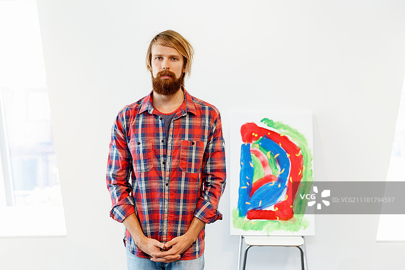 拿着画作的年轻男艺术家图片素材