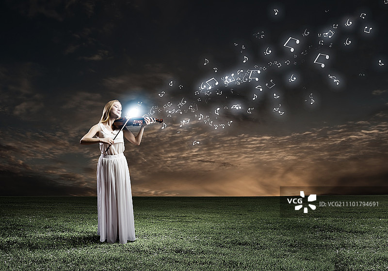 夜间演奏小提琴的白裙女子图片素材