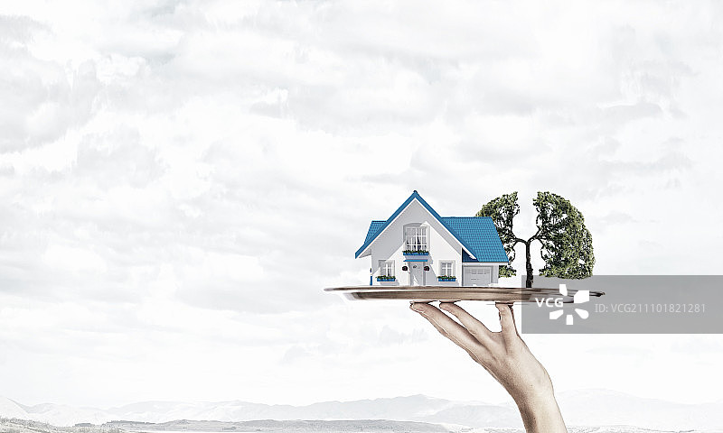 房地产推介：服务员用托盘展示房屋模型图片素材