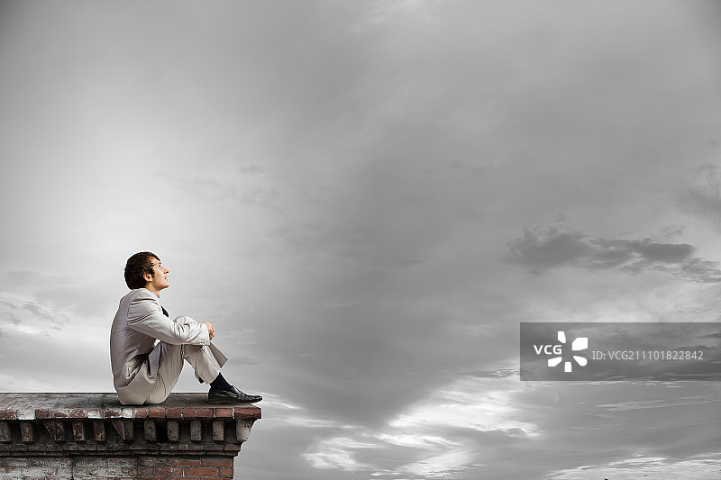 在屋顶休息的白西装商人图片素材