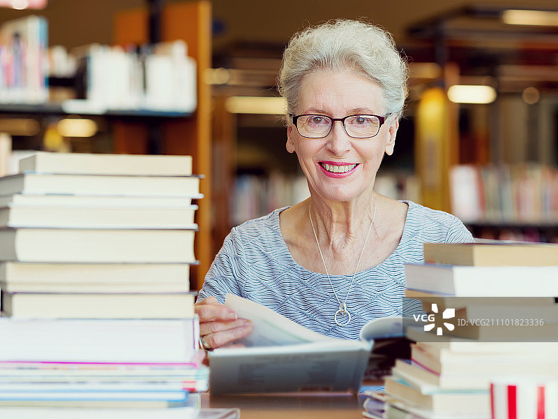 在图书馆看书的老年妇女图片素材