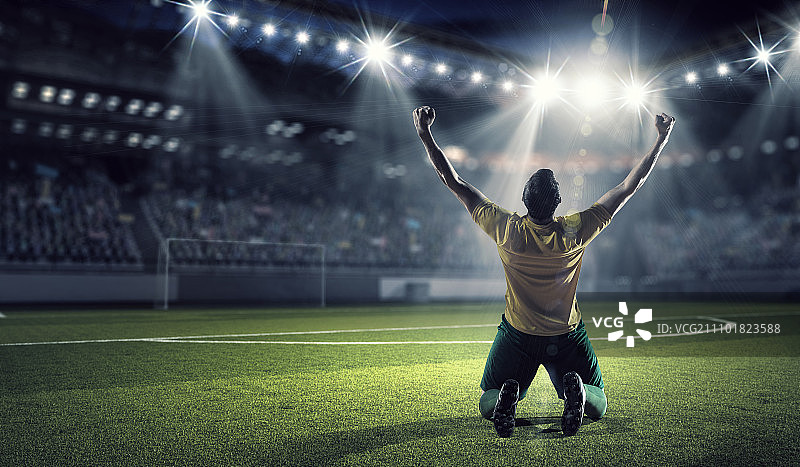 他是冠军。足球运动员手捧奖杯庆祝胜利图片素材