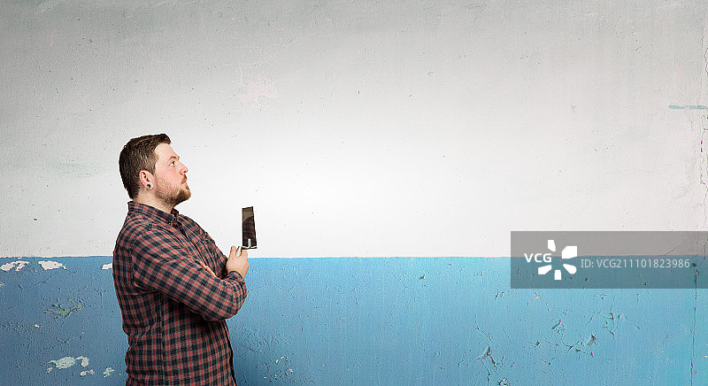 家庭装修：手持刮刀的男子图片素材