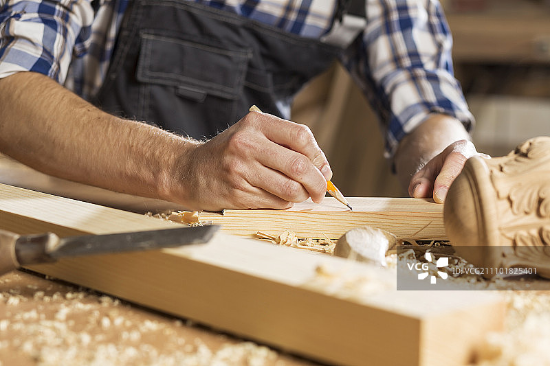 年轻木匠在他的工作室里用切割机工作图片素材