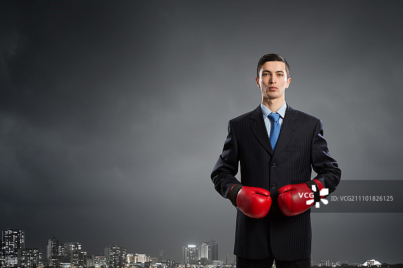 他为成功而奋斗：西装革履、戴着拳击手套的商人图片素材