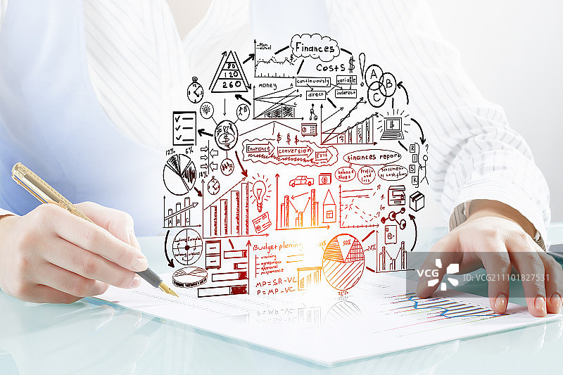 女商人伏案工作，手持笔书写商业策略特写图片素材