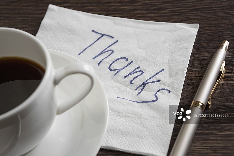 写在餐巾上的消息木桌上的餐巾和咖啡杯上的浪漫消息图片素材