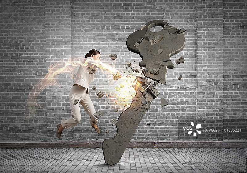 女人打碎钥匙，愤怒的女商人一拳击碎石制钥匙图片素材
