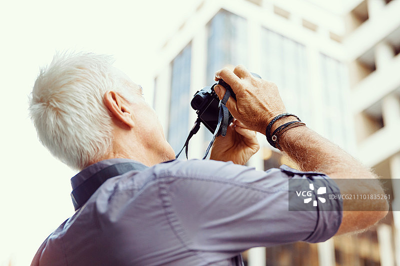 在城市里寻找拍摄地点的年长男人图片素材