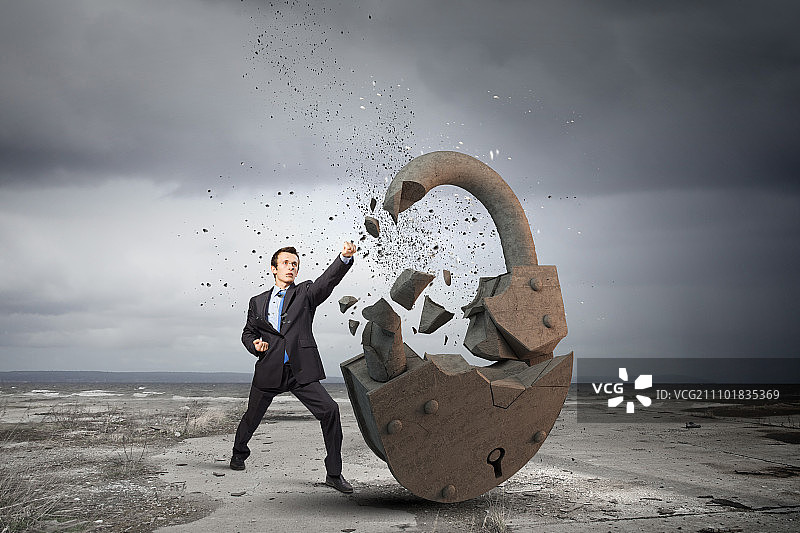 安全概念：商人用空手道踢腿打破石锁图片素材