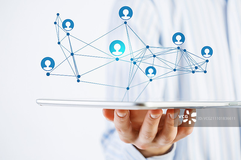 社交网络结构概念。商人手持平板电脑展示社交网络概念的近景图片素材