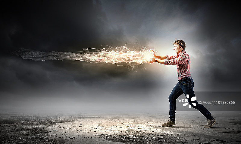 超能力者：投掷火球的休闲年轻男子图片素材