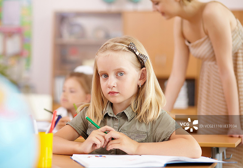 坐在学校课堂里学习的小女孩图片素材