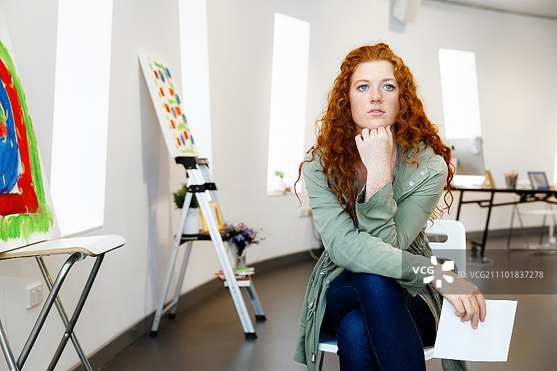 展示自己画作的年轻女艺术家，在画廊展示自己画作的年轻女艺术家图片素材