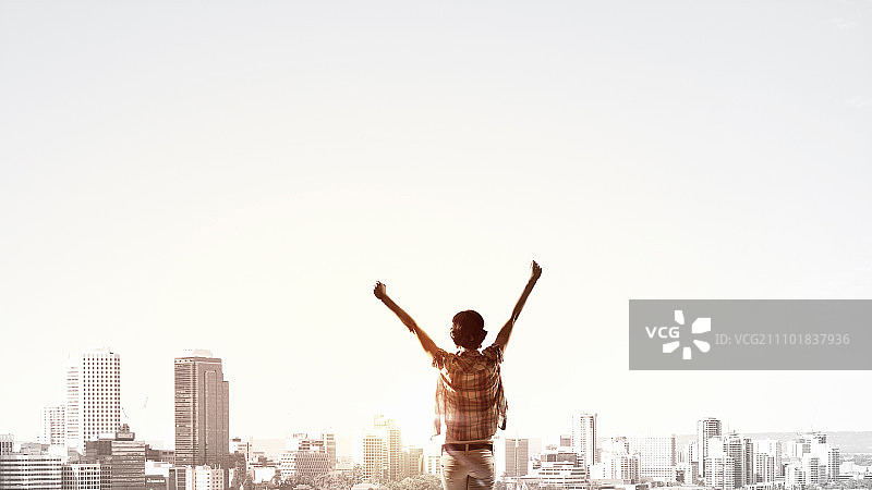 面朝新的一天：快乐的女子双手举起，面朝日出图片素材