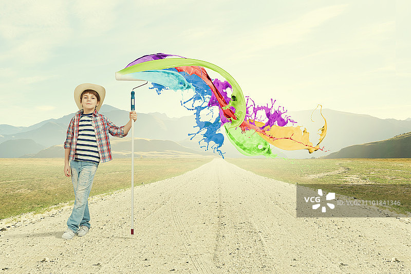 多彩的童年：学龄男孩用刷子在墙上绘画图片素材