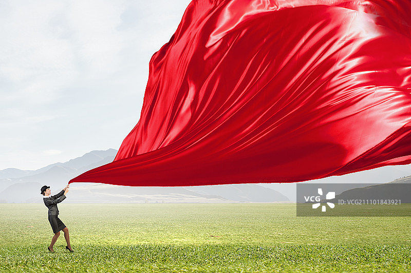 女子拉着服装banner。身穿西装和圆顶硬礼帽的年轻女商人拉着窗帘图片素材