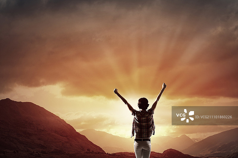 面朝新的一天：快乐的女子双手举起，面朝日出图片素材