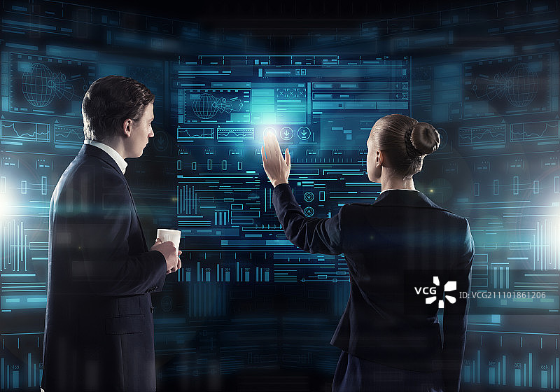 使用现代技术：商务人士使用虚拟面板界面工作的后视图图片素材