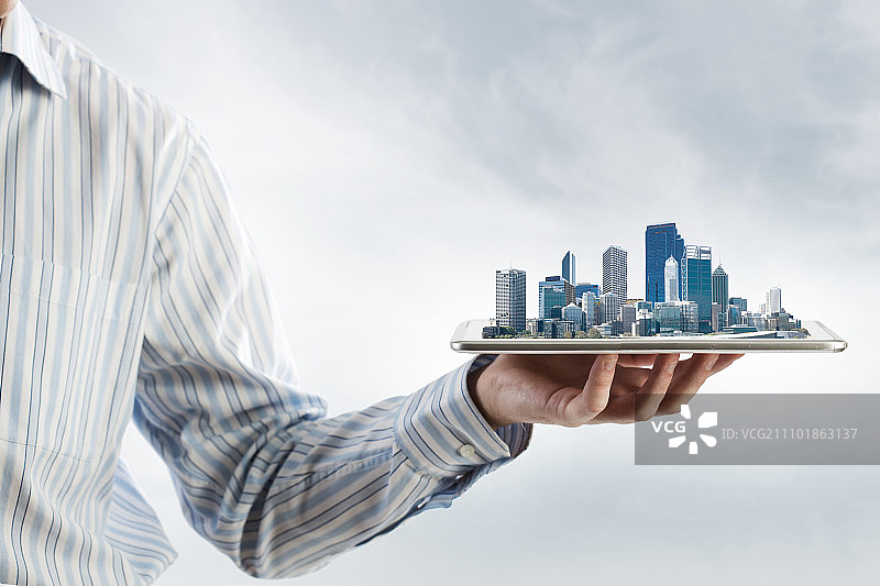 现代城市模型：手持平板电脑展示城市景观图片素材