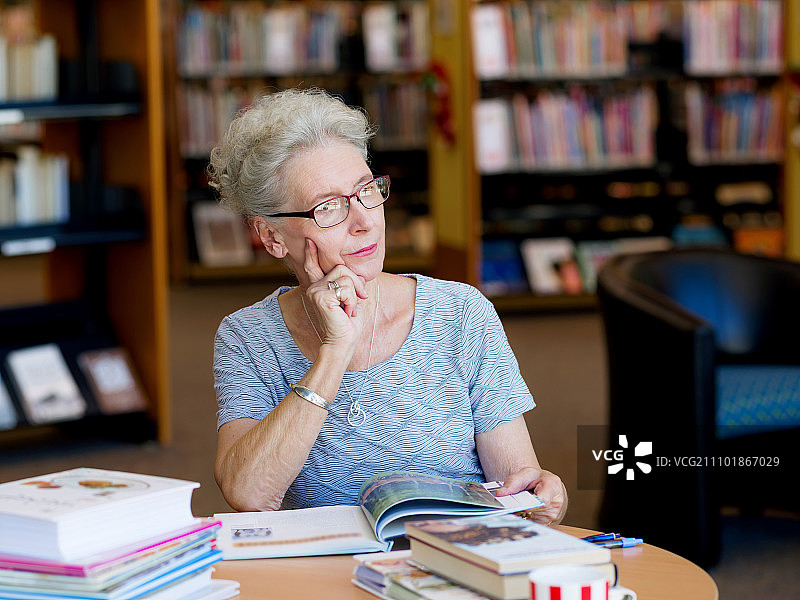 在图书馆看书的老年妇女图片素材