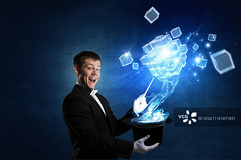 戴着高筒帽的男魔术师。年轻快乐的商人用魔法帽变戏法图片素材