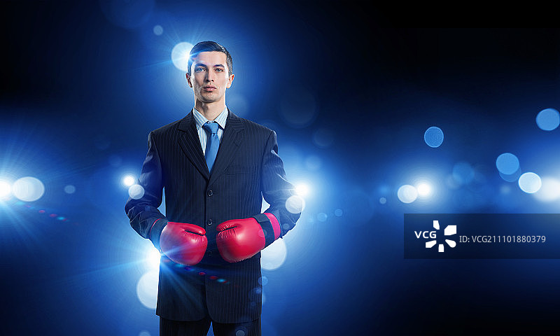 他为成功而奋斗：西装革履、戴着拳击手套的商人图片素材