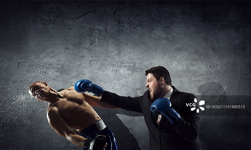商业竞争精神：西装革履的商人在水泥房间里与对手搏斗图片素材